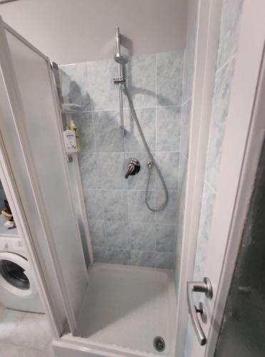 ducha con puerta de cristal y ducha en La Casa di Leo - Milano Bovisa en Milán