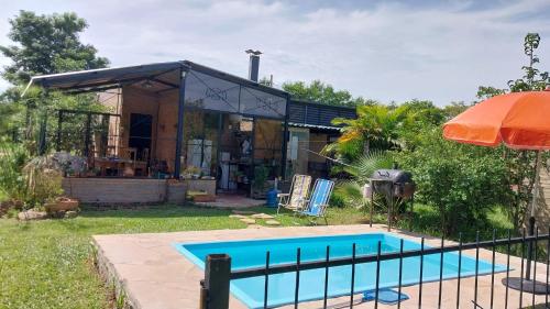 a house with a swimming pool in the yard at La casita del lago in Ypacarai