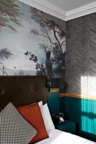 a bedroom with a bed with a painting on the wall at The Portico Hotel in London
