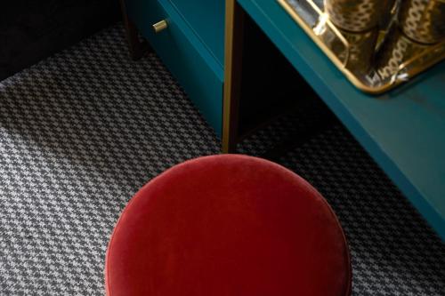 a red chair sitting in front of a table at The Portico Hotel in London