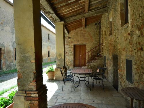 an outdoor patio with a table and chairs at Belvilla by OYO Allodola in Volterra