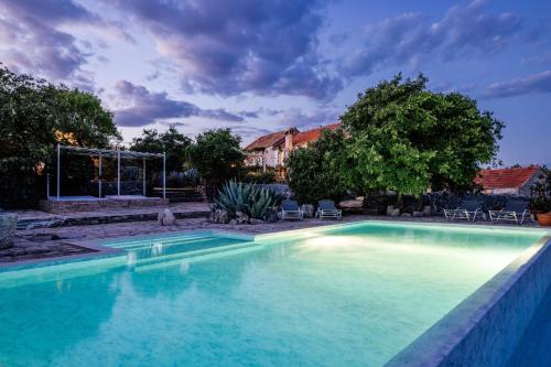 una piscina con acqua blu in un cortile di Outstanding Hvar Villa - 4 Bedrooms - Villa Dvori Pogled - Tennis Court - Incredible Sea Views a Jelsa (Gelsa)