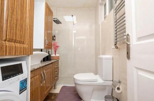 a bathroom with a white toilet and a sink at Purple Home in Keçiören