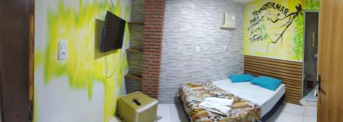 a small room with a bed in a brick wall at Pousada João de Barro in Camaçari