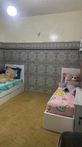 a bedroom with two beds with stuffed animals on them at Dikra apparemment in Fez