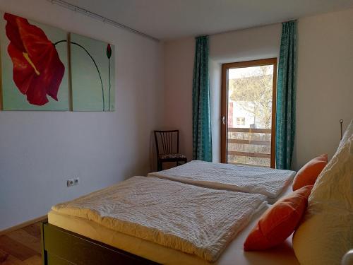 1 dormitorio con 2 camas y una ventana con una pintura floral en Bioferienhaus Westerwald, en Sankt Katharinen