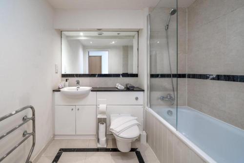 a bathroom with a toilet and a sink and a shower at Luxury 1 Bed Apartment Close To Excel & o2 in London