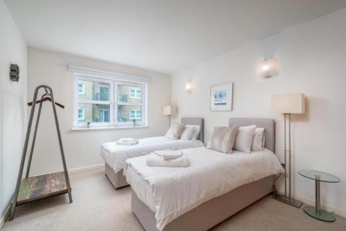 1 dormitorio con 2 camas y ventana en Luxury 1 Bed Apartment Close To Excel & o2 en Londres