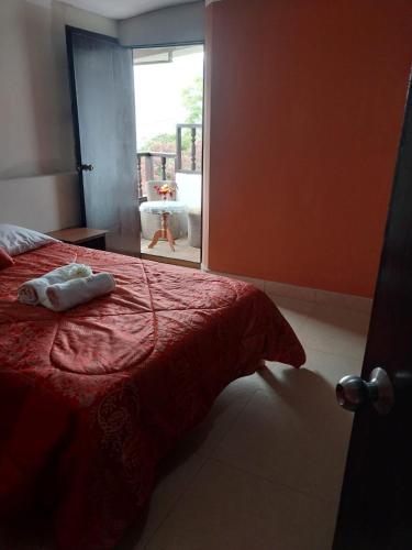 a bedroom with a red bed with two towels on it at Monte Gocta in Valera