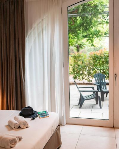 une chambre d'hôtel avec un lit et une porte coulissante en verre dans l'établissement Hôtel du cros d'Auzon, à Saint-Maurice-dʼArdèche