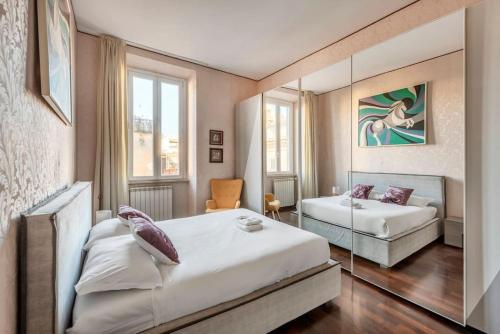 a hotel room with two beds and a mirror at Stunning Center Rome Apartment in Rome