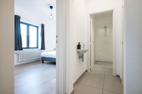 een witte kamer met een wastafel en een badkamer bij General Sixty-Seven by Romy&Travis in Brugge