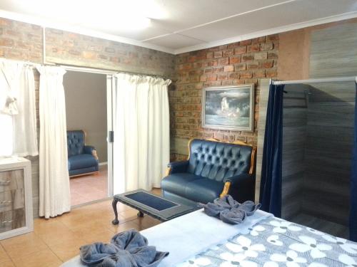 ein Wohnzimmer mit einem Bett und einem Sofa in der Unterkunft Aub Guesthouse - Mariental in Mariental