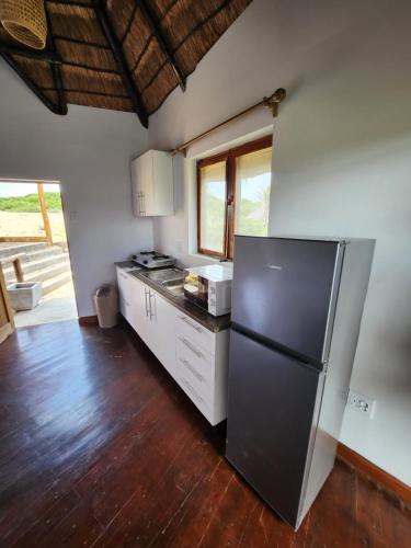 a kitchen with a stainless steel refrigerator and wooden floors at Cabana Beach Lodge in Cabo Conguiane