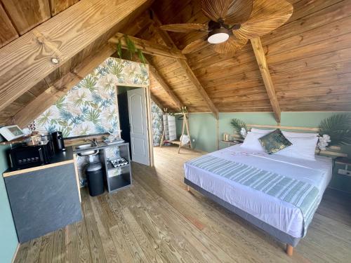 1 dormitorio con cama y techo de madera en Anaélodge piscine privée chauffée 30 degrés, en Le Tampon