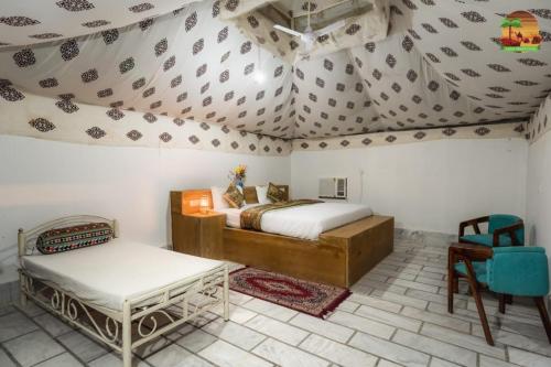 a bedroom with a bed and a table in a room at ARMAN DESERT RESORT in Sām