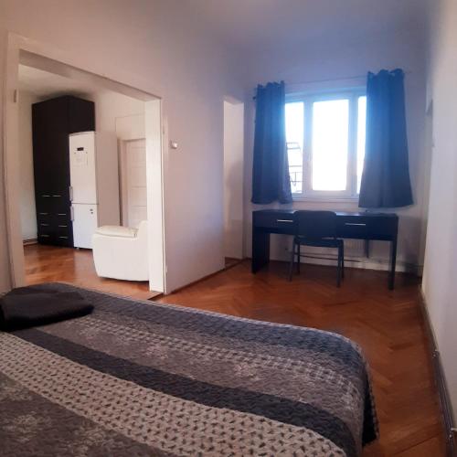 una camera da letto con un letto, una scrivania e una finestra di APARTMENT POPS 2 a Cluj-Napoca