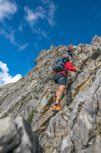 a man climbing up the side of a rocky mountain at Haus Mellenbach in Mellau
