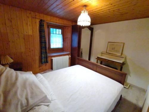 - une chambre avec un lit blanc et un piano dans l'établissement Maison de village - montagne, à Landry