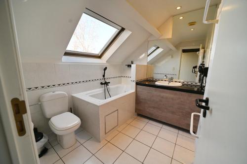 La salle de bains est pourvue de toilettes, d'un lavabo et d'une fenêtre. dans l'établissement Résidences Durbuy, à Durbuy