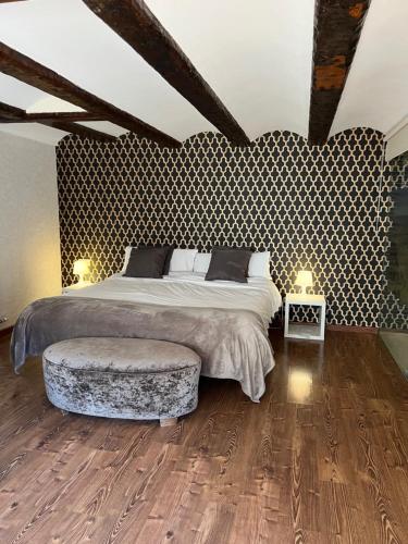 a bedroom with a large bed and a ottoman at Hospederia El Batan in Tramacastilla