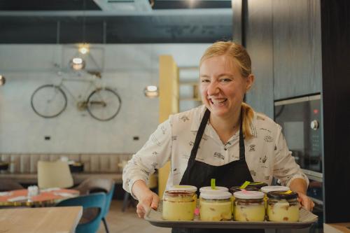 a woman in a kitchen holding a tray of food at iQ Hotel Roma in Rome