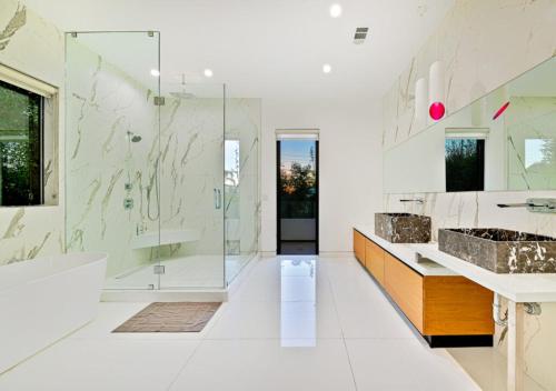 a bathroom with two sinks and a tub and a shower at Stylish & Modern 5 Bedroom Villa in Los Angeles