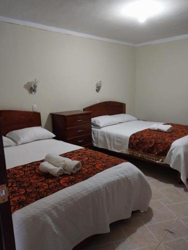 Habitación de hotel con 2 camas con sábanas blancas en Monte Gocta en Valera