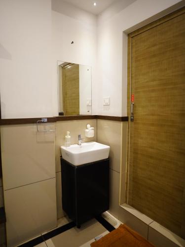 a bathroom with a sink and a mirror at ABUDHABI RESIDENCY in Palakkad