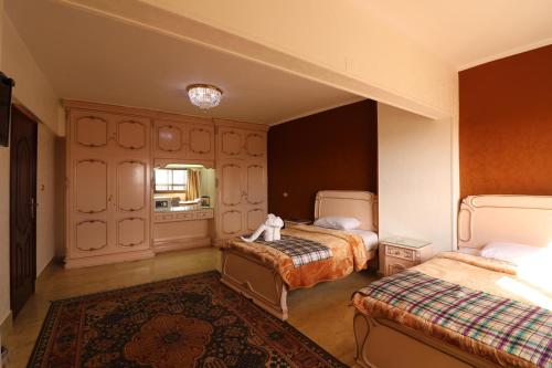 a bedroom with two beds and a rug at Jasmine Nile Sky Hotel in Cairo