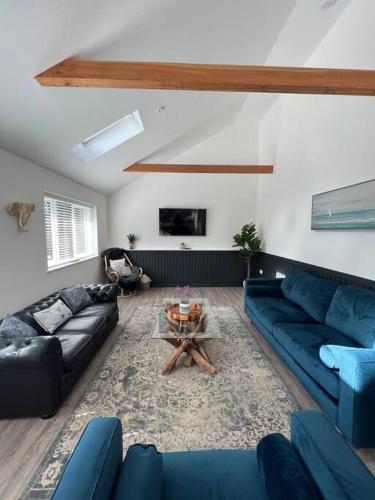 a living room with blue couches and a table at Rare Luxury Holiday Home with Hot-Tub in Belton