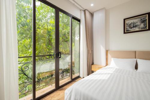 a bedroom with a bed and a large window at Studio-Vincent Apartment HaNoi in Hanoi