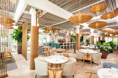 a restaurant with tables and chairs and chandeliers at Sian Oceanfront Condos in Hollywood
