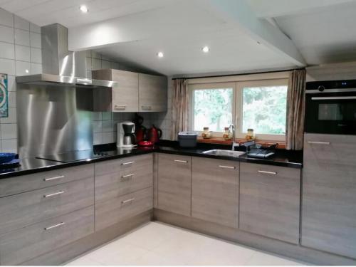una cocina con electrodomésticos de acero inoxidable y una ventana en Authentic chalet in Wibrin with private fish pond, en Wibrin