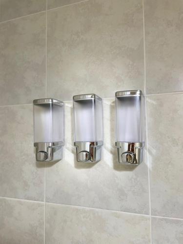 two soap dispensers on the wall of a bathroom at Dpto Pleno Centro con Asador y Cochera in Santa Fe