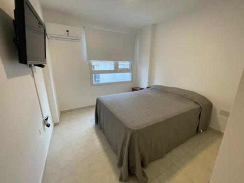 a bedroom with a bed and a flat screen tv at Dpto Pleno Centro con Asador y Cochera in Santa Fe