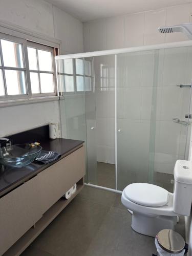 a bathroom with a toilet and a glass shower at Apto aconchegante no Centro in Jaguarão