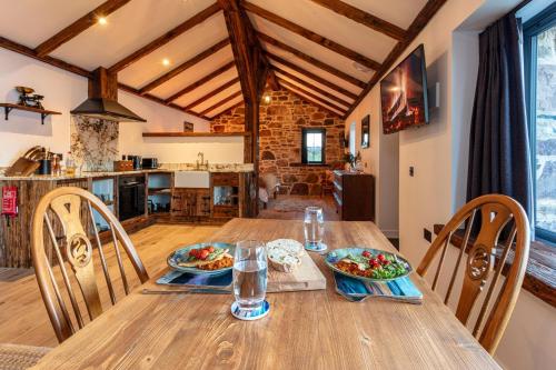 uma sala de jantar com uma mesa de madeira e cadeiras em The Ruin - Lochside Cottage dog friendly em Ullapool