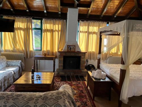 a living room with a bed and a fireplace at Muntenia Inn Apartments and Suites in Kalavrita