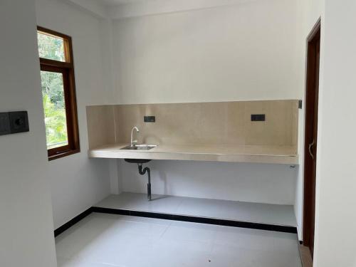a white bathroom with a sink and a window at Samarathunga Guest House in Katunayake
