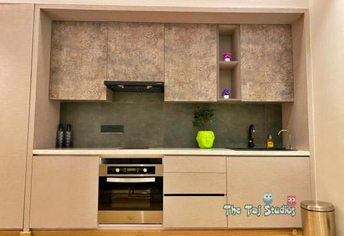 a kitchen with a stove top oven in a room at Super Luxurious Stay at Biggest Mall Galaxy Blue Sapphire,Bar, Club, US Cinemas, Food Court, SuperMart etc, by Taj Studios in Ghaziabad