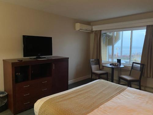Habitación de hotel con cama y TV de pantalla plana. en Ocean View Hotel, en Rocky Harbour
