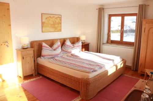 een slaapkamer met een rieten bed met kussens en een raam bij stay & relax am Bio Archehof Zachhiesen in Seekirchen am Wallersee