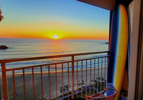 a view of the beach from a balcony with a sunset at E7 9th floor in Yangyang
