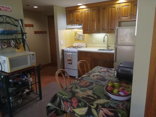a kitchen with a table with a bowl of fruit on it at Ski to your back door! Shared condo with ski professional and cat. in Warren