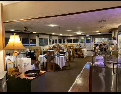 een eetkamer met tafels en stoelen en een restaurant bij swan hotel resturant bar and grill in Wellington