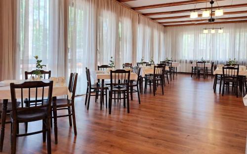 un salón de banquetes con mesas, sillas y ventanas en SUS Mazuria, en Rybitwy