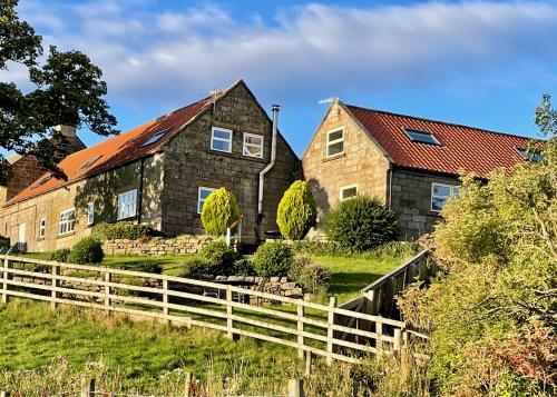 a house with a fence in front of it at Church House Farm in Danby