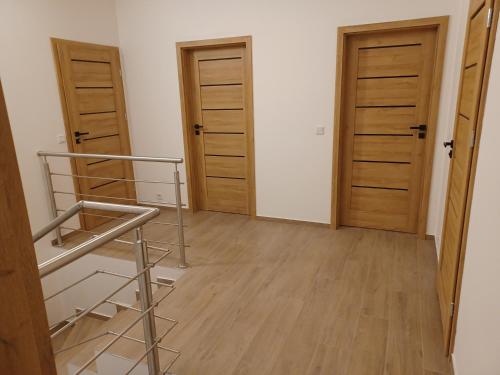 a room with two wooden doors and a staircase at AJP Prestige House Szczecin Załom in Szczecin