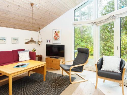 uma sala de estar com um sofá, cadeiras e uma mesa em 8 person holiday home in Grenaa em Grenå